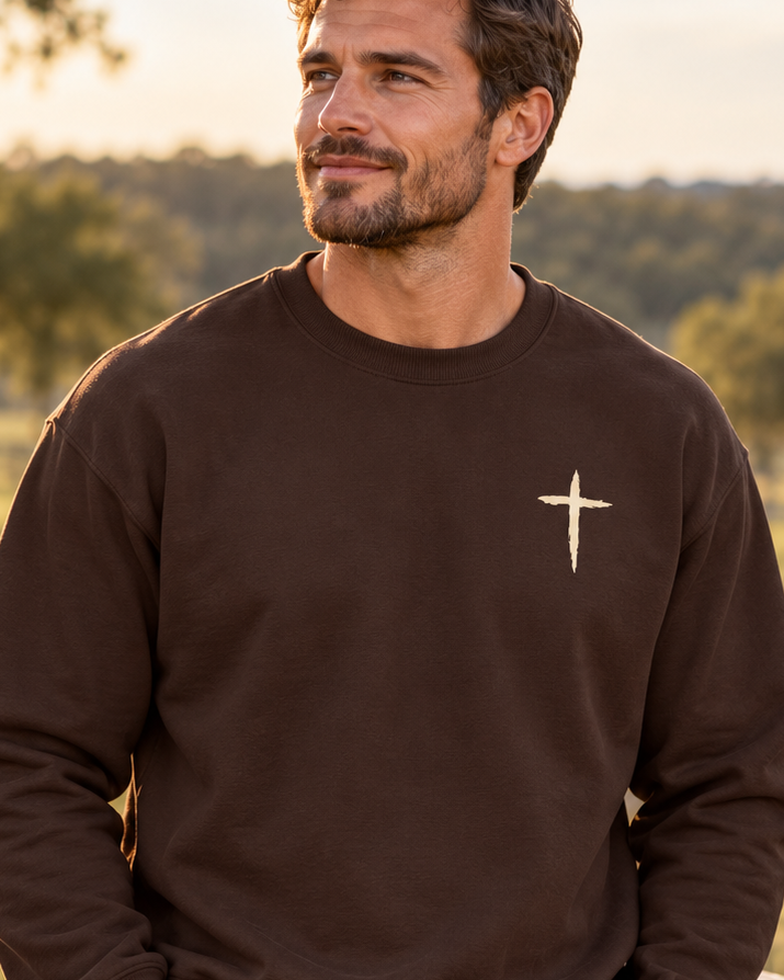The Cross Crewneck — Dark Chocolate, worn outdoors, chest cross detail