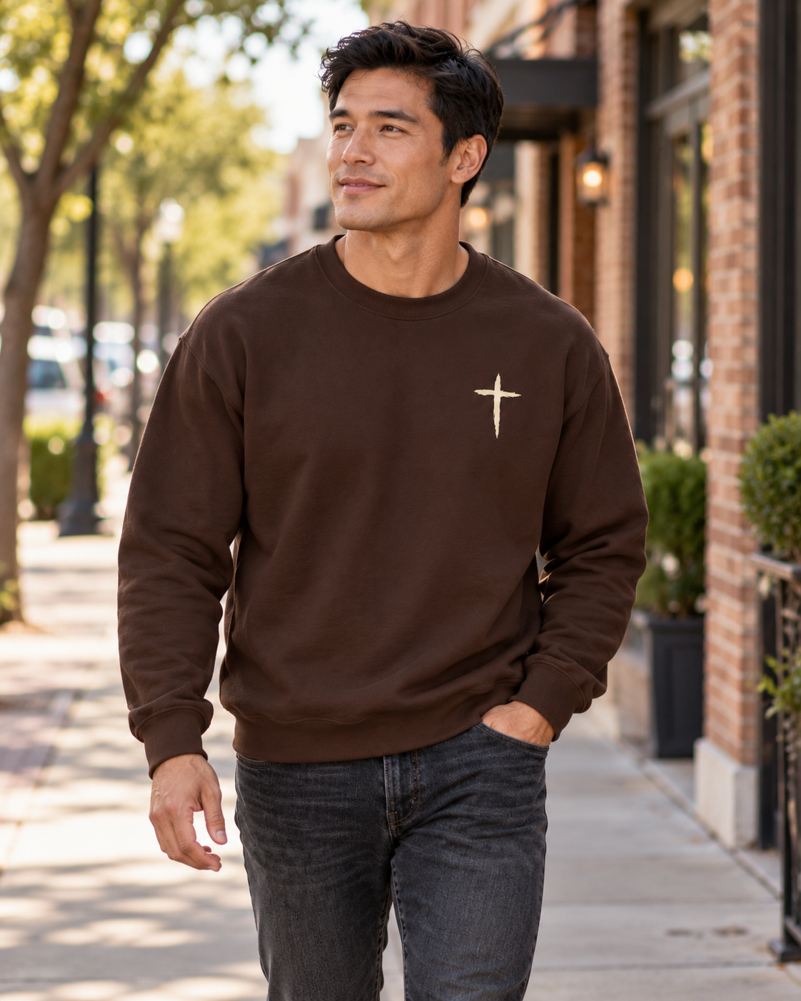 The Cross Crewneck — Dark Chocolate, worn on a town sidewalk
